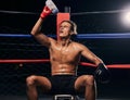 Boxing athlete with water bottle, tired after workout, training or exercise in a ring. Professional boxer rest and