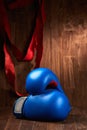 Boxing background with gloves and red bandage against wooden background.