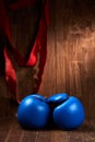 Boxing background with gloves and red bandage against wooden background.