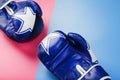 Boxing blue gloves on a pink and blue background diagonally