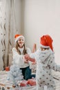 Boxing day. Little baby girl and mom unpack pink gift boxes near the Christmas tree. The kid touches bright Christmas-tree Royalty Free Stock Photo