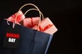 Boxing day Sale text on a black tag with shopping bag and gift box on black background. Online Shopping Royalty Free Stock Photo