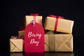 Boxing day Sale text on a red tag with stack of gift boxes on black background. Online Shopping Royalty Free Stock Photo