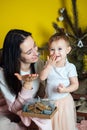 Boxing day and unpacking Christmas gift boxes. Cute Little baby toddler girl and mom unpack gift boxes near the Royalty Free Stock Photo