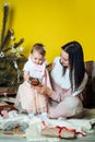 Boxing day and unpacking Christmas gift boxes. Cute Little baby toddler girl and mom unpack gift boxes near the Royalty Free Stock Photo