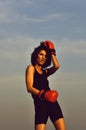 Boxing girl boxer against blue sky in red gloves Royalty Free Stock Photo
