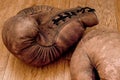 Boxing gloves. Old vintage retro pair of leather worn mittens are on the wood table. Red colors and soft lights