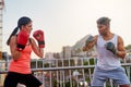 Boxing, people and outdoor training in city, trainer and fitness or workout for strong power. Couple, town bridge and