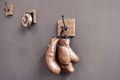 Boxing school. Final sparring. Vintage boxing gloves hang on hook wall background. Boxing gloves and ring bell. Boxing