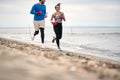 Boxing sparring man and woman running along beach together Royalty Free Stock Photo