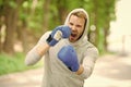 Boxing training endurance. Man athlete concentrated face with sport gloves practicing boxing nature background. Boxer