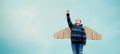 Child pilot aviator with toy paper wings airplane dreams of traveling