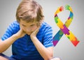 Boy against grey background with autism color spectrum hands ribbon Royalty Free Stock Photo