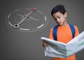 Boy against grey background reading map information and orienteering and compass