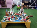 The boy at the age of 3 years plays with the wooden children`s railroad in a children`s corner in entertainment center, the front