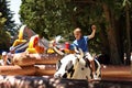 A boy, aged 6-8 rides a mechanical bull at a Independence Day celebration.