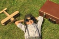 A boy with an airplane, Happy child dreams of becoming a pilot, lying on the grass. Retro toned