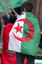 Boy with Algerian Flag on his Shoulders next to a Girl with Moroccan Flag on her Shoulders during a Political Demonstration