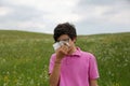 Boy with allergy and pink t-shirt blows his nose using a handker Royalty Free Stock Photo