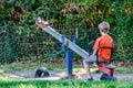 Boy alone playing at the see-saw in the playground