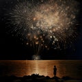 A boy, alone, watching a fireworks show by the lake. New Year\'s fun and festiv Royalty Free Stock Photo