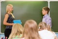 Boy answers questions of teachers near a school board Royalty Free Stock Photo