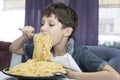 Boy is appetizing eats a large Italian spaghetti