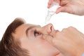 Boy applying eye drop on white background Royalty Free Stock Photo