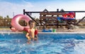 Boy with armbands playing with toys near the pool with clear water on the background of a summer sunset Royalty Free Stock Photo