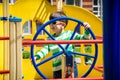 Boy as a captain or sailors play on the ship outdoors on sunny day. Kid has a lot of fun. Ship has colorful flags on wind Royalty Free Stock Photo