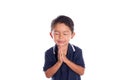 Boy asking for forgiveness with closed eyes, isolated on white background. Latin boy joins hands while praying in front