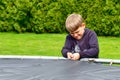 The boy assembles a new trampoline and tensions the springs Royalty Free Stock Photo