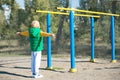 Boy athlete doing pull ups.Active lifestyle. The child performs exercises on uneven bars on the street. Royalty Free Stock Photo