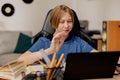 A boy attending an elementary school has lessons with his teacher remotely via the Internet, the child waves to laptop Royalty Free Stock Photo