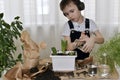 The child in planting the flowers of hyacinths, pours water from the jug, water droplets trickles into the flower pot Royalty Free Stock Photo