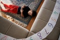 A boy with autism lies on the floor after putting the numbers in order. Royalty Free Stock Photo