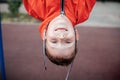 A boy in autumn clothes hangs upside down on the playground. Royalty Free Stock Photo