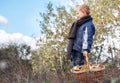 Boy in autumn forest with ful basket of mushrooms