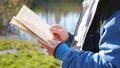 Boy in autumn Park near the lake reading a book. A beautiful autumn landscape. School education Royalty Free Stock Photo