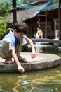 Boy awaits for little fish to swim into his net, Royalty Free Stock Photo