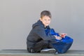 Boy with backpack sitting on the bench after school Royalty Free Stock Photo