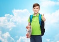 Boy with backpack and skateboard showing thumbs up Royalty Free Stock Photo