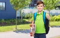 boy with backpack and skateboard showing thumbs up Royalty Free Stock Photo