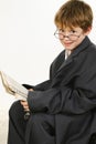 Boy in Baggy Suit Reading Newspaper Royalty Free Stock Photo