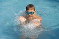 Boy bathes in the pool wearing swimming goggles Royalty Free Stock Photo