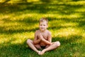 Boy Yogi sits on green grass