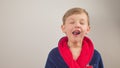 boy in a bathrobe posing at the camera on a white background Royalty Free Stock Photo