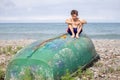 A boy on the beach sits