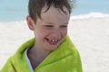 The boy on the beach wrapped in a towel, wet after swimming, Royalty Free Stock Photo