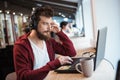 Boy with beard using laptop and listening to music Royalty Free Stock Photo